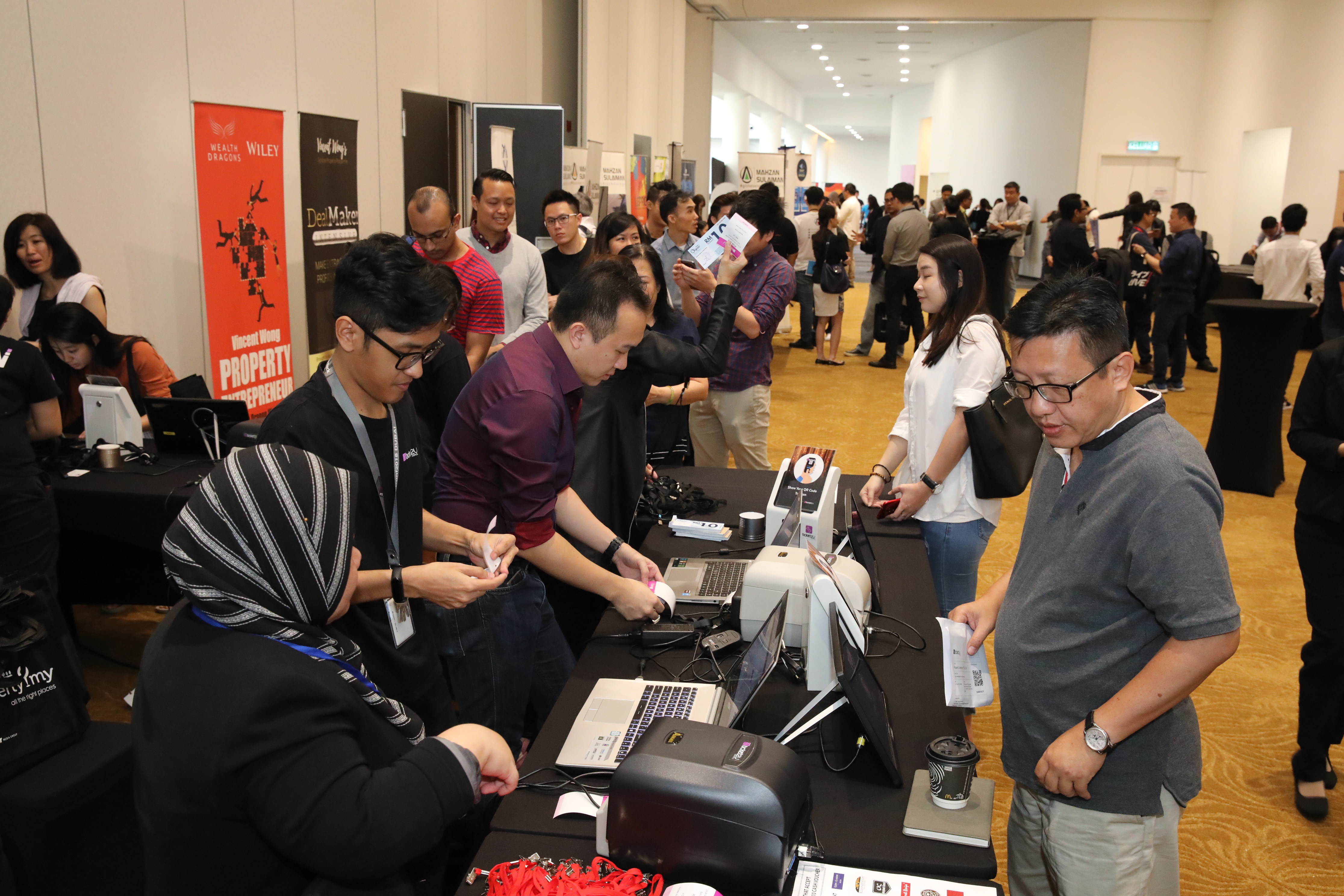 Attendees at the registration counter and networking at expo booths.